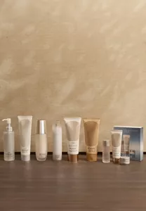 Gamme de produits de soin SENSAI conçus pour limiter l'impact sur l'environnement sur une surface beige sur fond neutre